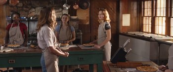 Movie still from “They/Them” (2022), directed by John Logan – A group of people standing around a table; Medium shot, Over the shoulder angle