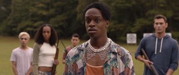 Movie still from “They/Them” (2022), directed by John Logan – A man in a floral shirt with a necklace; Close Up shot, Over the shoulder angle
