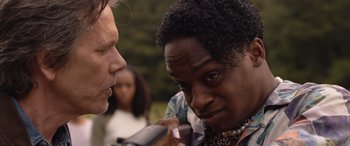 Movie still from “They/Them” (2022), directed by John Logan – A woman is looking at a man with a microphone in her hand; Close Up shot, Over the shoulder angle