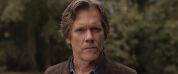 Movie still from “They/Them” (2022), directed by John Logan – A person wearing a brown jacket; Close Up shot, Low angle