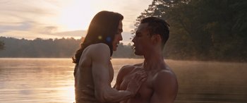 Movie still from “They/Them” (2022), directed by John Logan – A man and a woman are standing in the water; Medium shot, High angle
