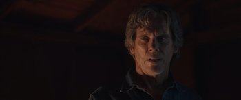 Movie still from “They/Them” (2022), directed by John Logan – A person wearing a black shirt; Close Up shot, Over the shoulder angle