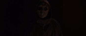 Movie still from “They/Them” (2022), directed by John Logan – A person wearing a skull mask and a hooded jacket; Close Up shot, Low angle