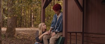 Movie still from “They/Them” (2022), directed by John Logan – A man and a woman sitting on a bench in the woods; Medium shot, Over the shoulder angle