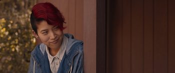 Movie still from “They/Them” (2022), directed by John Logan – A woman with red hair is leaning against a wall; Close Up shot, Over the shoulder angle