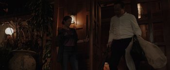 Movie still from “Thirteen Lives” (2022), directed by Ron Howard – A woman and a man standing next to each other in front of a door; Medium shot, Over the shoulder angle