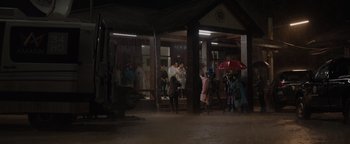 Movie still from “Thirteen Lives” (2022), directed by Ron Howard – A group of people standing under an awning; Extreme Wide shot, Low angle