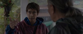 Movie still from “Thirteen Lives” (2022), directed by Ron Howard – A young man in a red raincoat talking to a man in a blue raincoat; Close Up shot, Over the shoulder angle