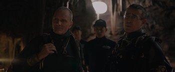 Movie still from “Thirteen Lives” (2022), directed by Ron Howard – A group of men standing next to each other in a cave; Close Up shot, Over the shoulder angle