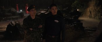 Movie still from “Thirteen Lives” (2022), directed by Ron Howard – Two men standing next to each other in a dark area; Medium shot, Over the shoulder angle