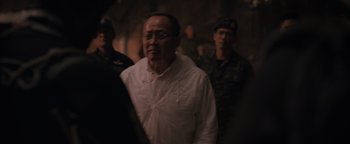 Movie still from “Thirteen Lives” (2022), directed by Ron Howard – A group of men standing next to each other in a dark room; Medium shot, Over the shoulder angle