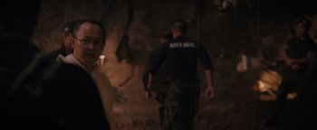 Movie still from “Thirteen Lives” (2022), directed by Ron Howard – A man standing in front of two men in military fatigues; Close Up shot, Over the shoulder angle