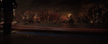 Movie still from “Thirteen Lives” (2022), directed by Ron Howard – A group of people sitting in a cave; Wide shot, Low angle
