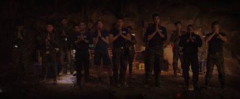 Movie still from “Thirteen Lives” (2022), directed by Ron Howard – A group of men standing next to each other in the dark; Wide shot, High angle