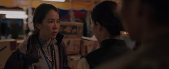 Movie still from “Thirteen Lives” (2022), directed by Ron Howard – Two women are talking in a room filled with boxes; Close Up shot, Over the shoulder angle