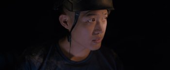 Movie still from “Thirteen Lives” (2022), directed by Ron Howard – A young man wearing a helmet is looking into the distance; Close Up shot, Low angle