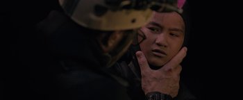 Movie still from “Thirteen Lives” (2022), directed by Ron Howard – A man in a helmet is touching his face; Close Up shot, Over the shoulder angle