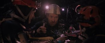 Movie still from “Thirteen Lives” (2022), directed by Ron Howard – A man wearing a helmet while holding a pair of scissors; Close Up shot, Over the shoulder angle