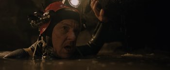 Movie still from “Thirteen Lives” (2022), directed by Ron Howard – A man with a helmet on and a flashlight on his head; Close Up shot, Low angle