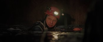 Movie still from “Thirteen Lives” (2022), directed by Ron Howard – A man with a helmet and a light on his head; Close Up shot, Low angle