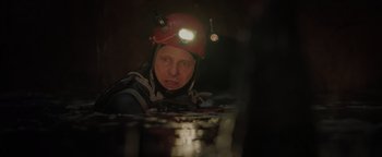 Movie still from “Thirteen Lives” (2022), directed by Ron Howard – A man wearing a helmet while looking at something; Close Up shot, Over the shoulder angle