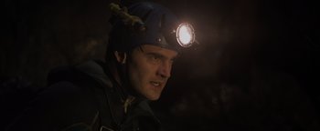 Movie still from “Thirteen Lives” (2022), directed by Ron Howard – A man wearing a hard hat with a light on his head; Close Up shot, Low angle