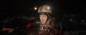 Movie still from “Thirteen Lives” (2022), directed by Ron Howard – A man wearing a helmet while standing in water; Close Up shot, Over the shoulder angle