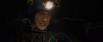 Movie still from “Thirteen Lives” (2022), directed by Ron Howard – A man wearing a helmet and a light on his head; Close Up shot, Over the shoulder angle