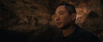 Movie still from “Thirteen Lives” (2022), directed by Ron Howard – A person wearing a black shirt in a cave; Close Up shot, Over the shoulder angle