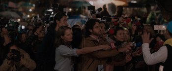 Movie still from “Thirteen Lives” (2022), directed by Ron Howard – A group of people standing next to each other holding microphones; Medium shot, Over the shoulder angle
