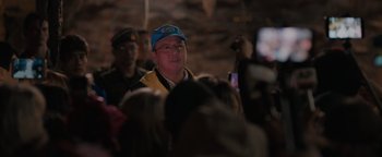 Movie still from “Thirteen Lives” (2022), directed by Ron Howard – A man wearing a blue hat and a yellow vest; Close Up shot, Over the shoulder angle