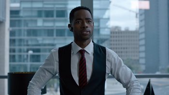 Movie still from “Escape Room” (2019), directed by Adam Robitel – A man wearing a vest and a red tie; Medium shot, Over the shoulder angle