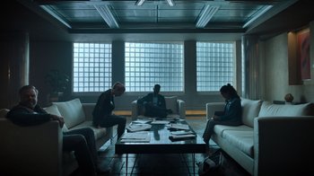 Movie still from “Escape Room” (2019), directed by Adam Robitel – A group of people sitting around a living room; Wide shot, Low angle