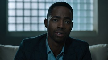 Movie still from “Escape Room” (2019), directed by Adam Robitel – A person wearing a suit and tie; Close Up shot, Over the shoulder angle