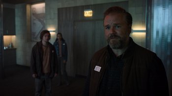 Movie still from “Escape Room” (2019), directed by Adam Robitel – A man standing in front of two other people in a room; Medium shot, Over the shoulder angle