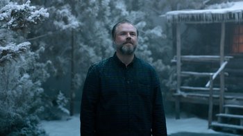 Movie still from “Escape Room” (2019), directed by Adam Robitel – A man standing in front of a snowy forest; Medium shot, Low angle