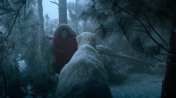 Movie still from “Escape Room” (2019), directed by Adam Robitel – A woman in a red coat walking a dog through the woods; Wide shot, Low angle