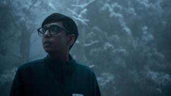 Movie still from “Escape Room” (2019), directed by Adam Robitel – A young man wearing glasses and a black jacket; Medium shot, Low angle