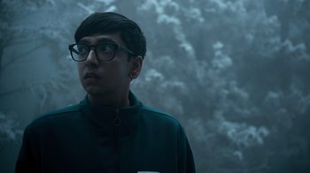 Movie still from “Escape Room” (2019), directed by Adam Robitel – A young man wearing glasses and a black jacket; Medium shot, Over the shoulder angle