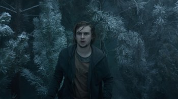 Movie still from “Escape Room” (2019), directed by Adam Robitel – A man standing in front of a tree in the dark; Medium shot, Low angle