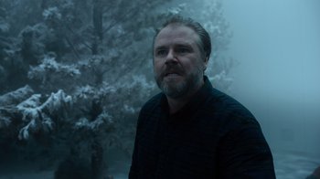 Movie still from “Escape Room” (2019), directed by Adam Robitel – A man with a goatee standing next to a tree; Close Up shot, Low angle