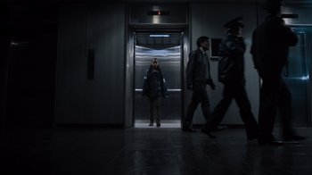 Movie still from “Escape Room” (2019), directed by Adam Robitel – A woman standing in an elevator in a dark room; Wide shot, Low angle