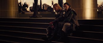Movie still from “Thor” (2011), directed by Kenneth Branagh – Two people sitting on some steps wearing armor; Medium shot, Low angle
