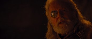 Movie still from “Thor” (2011), directed by Kenneth Branagh – An old man with a white beard wearing a pair of eye glasses; Close Up shot, Over the shoulder angle