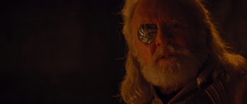Movie still from “Thor” (2011), directed by Kenneth Branagh – An old man with a white beard wearing a metal eye patch; Close Up shot, Over the shoulder angle