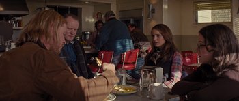 Movie still from “Thor” (2011), directed by Kenneth Branagh – A man and a woman sitting at a table with plates of food in front of them; Medium shot, Over the shoulder angle