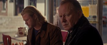 Movie still from “Thor” (2011), directed by Kenneth Branagh – Two people sitting at a table in front of each other; Close Up shot, Over the shoulder angle