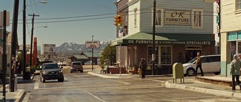 Movie still from “Thor” (2011), directed by Kenneth Branagh – A person walking down the street in front of a furniture store; Extreme Wide shot, High angle