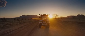 Movie still from “Thor” (2011), directed by Kenneth Branagh – A truck driving down a dirt road at sunset; Extreme Wide shot, Low angle