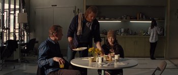 Movie still from “Thor” (2011), directed by Kenneth Branagh – A group of people sitting around a table with plates of food on it; Medium shot, Over the shoulder angle